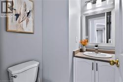 White vanity with integrated sink, sleek faucet, and framed mirror with sconce lighting - 