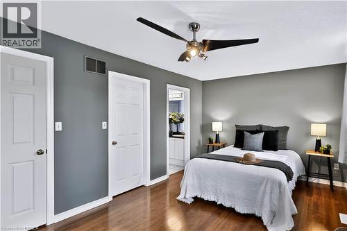 Wood-finish flooring, neutral grey walls, white trim, and a ceiling fan with integrated lighting - 19 Hyslop Drive, Caledonia, ON 