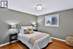 Hardwood-finish flooring, neutral wall paint, and a white ceiling with a flush-mount light fixture - 