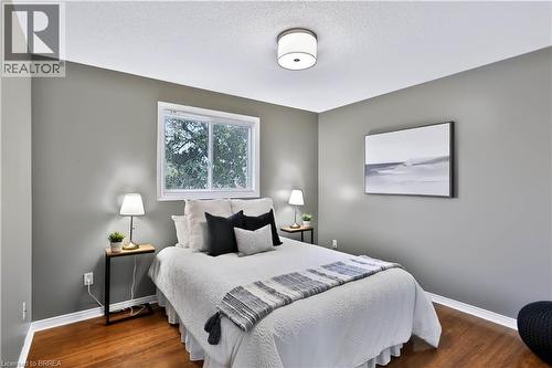 Hardwood flooring, neutral gray wall tones, ceiling-mounted light fixture, and white trim - 19 Hyslop Drive, Caledonia, ON 