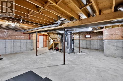 Unfinished basement with concrete flooring and exposed wooden joists - 19 Hyslop Drive, Caledonia, ON 