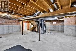 Unfinished basement with concrete flooring and exposed wooden joists - 