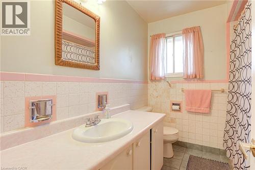 Single vanity with integrated sink, patterned wall tile, and a window for natural light - 8 Bonnylyn Drive, Kitchener, ON 