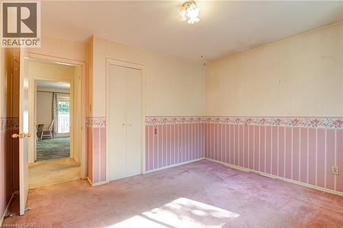 Carpeted room with bi-fold closet doors and a flush-mount ceiling light - 8 Bonnylyn Drive, Kitchener, ON 