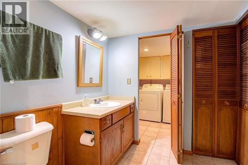 Vanity with a built-in sink, wood-finish cabinetry, and an attached mirror - 8 Bonnylyn Drive, Kitchener, ON 