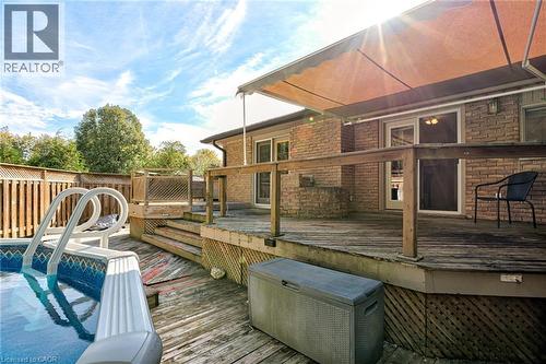 Expansive wood deck with a built-in privacy wall, outdoor pool, and a retractable awning - 8 Bonnylyn Drive, Kitchener, ON 