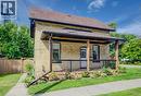 Brick exterior with a covered porch, dark brown railings, and a brown shingle roof - 185 Strange Street, Kitchener, ON  - Outdoor 