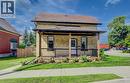 Brick exterior with a covered front porch featuring wood posts and black railings - 185 Strange Street, Kitchener, ON  - Outdoor With Deck Patio Veranda 