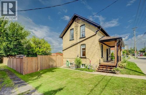 Brick exterior with a covered porch featuring wood decking - 185 Strange Street, Kitchener, ON - Outdoor