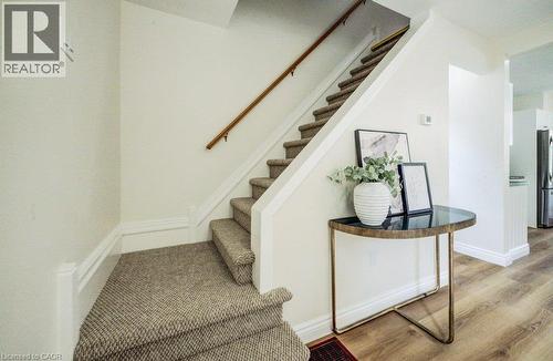 Carpeted staircase with wood handrail and light-toned walls - 185 Strange Street, Kitchener, ON - Indoor Photo Showing Other Room