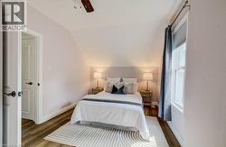Vaulted ceiling featuring a ceiling fan, wood-finish flooring, and white trim - 