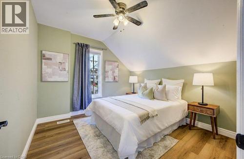 Wood-finish flooring, recessed window, ceiling fan with integrated lighting, and sloped ceiling - 185 Strange Street, Kitchener, ON - Indoor Photo Showing Bedroom