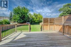 Expansive wood deck with horizontal slat privacy screens and railings featuring black metal balusters - 