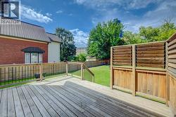 Expansive wood deck with railing and stairs, offering access to a manicured lawn - 