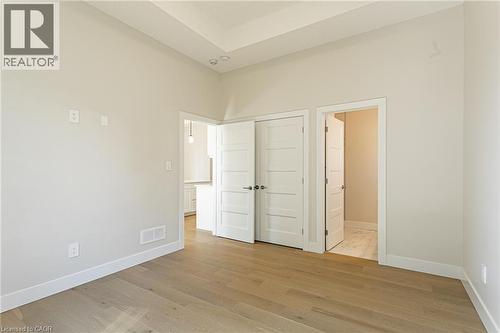 Wood-finish flooring, white trim, recessed lighting, and a tray ceiling - 7966 Fallon Drive Unit# 18, Lucan Biddulph (Twp), ON - Indoor Photo Showing Other Room