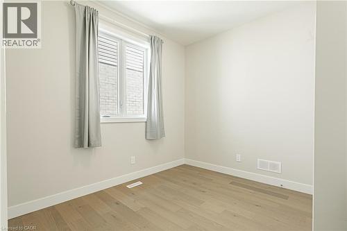 Neutral wall color, wood-finish flooring, white window trim, and white baseboards - 7966 Fallon Drive Unit# 18, Lucan Biddulph (Twp), ON - Indoor Photo Showing Other Room