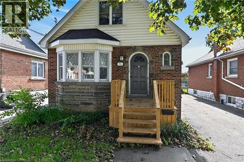Brick exterior with stone accents and a bay window - 75 Barons Avenue S, Hamilton, ON 