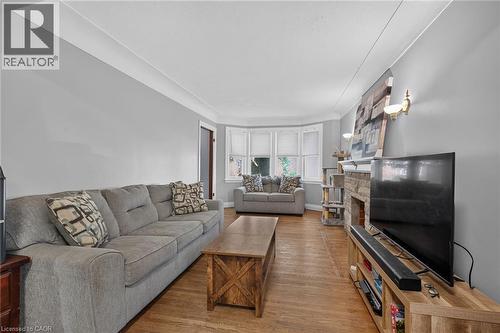 Bright living room featuring hardwood flooring, recessed ceiling details, and large windows providing natural light - 75 Barons Avenue S, Hamilton, ON 