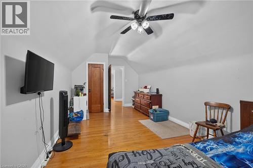 Hardwood flooring, sloped ceiling, ceiling fan with integrated lighting, wood-paneled door - 75 Barons Avenue S, Hamilton, ON 
