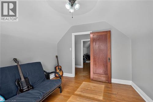 Sloped ceilings, wood-finish flooring, and a ceiling fan with light - 75 Barons Avenue S, Hamilton, ON 