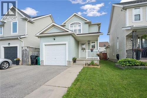Light blue siding exterior with an attached single-car garage, concrete walkway, and a small front porch with white railing - 765 Angler Way, Waterloo, ON - Outdoor With Facade