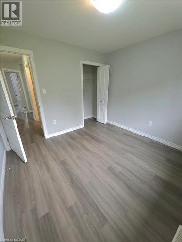 Bright, open bedroom featuring wood-finish flooring throughout, recessed ceiling lighting, and two generous closet spaces with white-trimmed doors - 998 Mapleridge Street, London, ON - Indoor Photo Showing Other Room