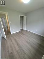 Bright, open bedroom featuring wood-finish flooring throughout, recessed ceiling lighting, and two generous closet spaces with white-trimmed doors - 