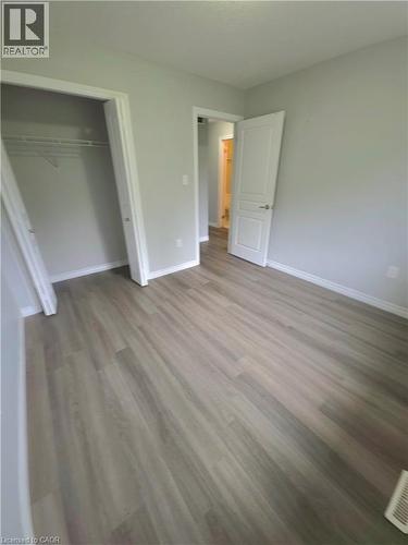 Wood-finish flooring throughout, light gray wall paint, white trim, and a bi-fold closet door - 998 Mapleridge Street, London, ON - Indoor Photo Showing Other Room