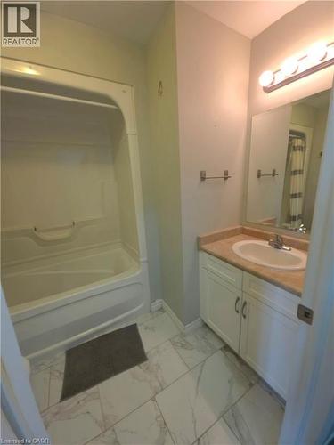 Bathroom featuring a white tub/shower combination, white vanity with cabinet storage, light-toned countertop, and tile flooring - 998 Mapleridge Street, London, ON - Indoor Photo Showing Bathroom