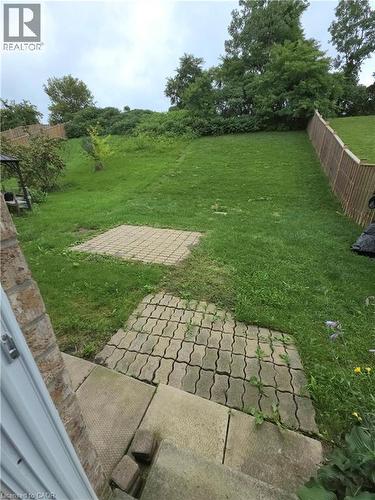 Expansive green space with mature trees, fenced perimeter, and paver stone patio areas - 998 Mapleridge Street, London, ON - Outdoor