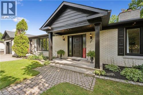 Light-colored brick exterior with black trim, a covered entryway with substantial columns, a paver walkway, an attached garage, and mature landscaping - 267 Abraham Street, Cambridge, ON - Outdoor