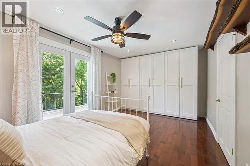Hardwood flooring, recessed lighting, ceiling fan with light fixture, built-in white panel cabinetry, and French doors leading to a balcony - 267 Abraham Street, Cambridge, ON - Indoor Photo Showing Bedroom