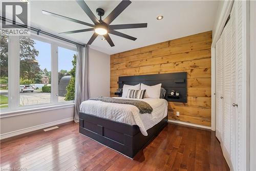 Hardwood flooring, natural wood accent wall, recessed lighting, ceiling fan with integrated lighting, and louvered closet doors - 267 Abraham Street, Cambridge, ON - Indoor Photo Showing Bedroom