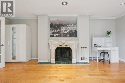 Hardwood flooring, recessed ceiling lighting, crown molding, marble fireplace surround, and French doors - 267 Abraham Street, Cambridge, ON - Indoor Photo Showing Living Room With Fireplace