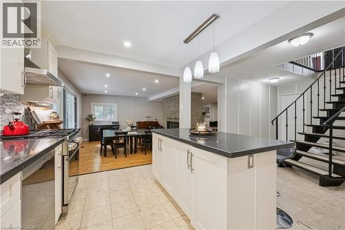Kitchen featuring an island with a dark countertop, white cabinetry, stainless steel appliances, and a tiled backsplash - 267 Abraham Street, Cambridge, ON - Indoor Photo Showing Other Room
