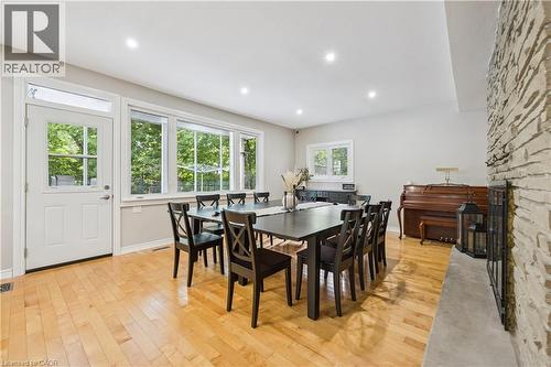 Light wood-finish flooring, recessed ceiling lights, large transom window, and stone-clad fireplace - 267 Abraham Street, Cambridge, ON - Indoor Photo Showing Dining Room