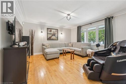 Hardwood flooring, crown molding, large window, ceiling-mounted light fixture, and wall sconces - 267 Abraham Street, Cambridge, ON - Indoor Photo Showing Living Room