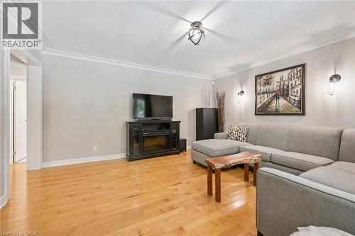 Hardwood flooring, crown molding, recessed lighting, wall sconces, and an electric fireplace - 267 Abraham Street, Cambridge, ON - Indoor Photo Showing Living Room