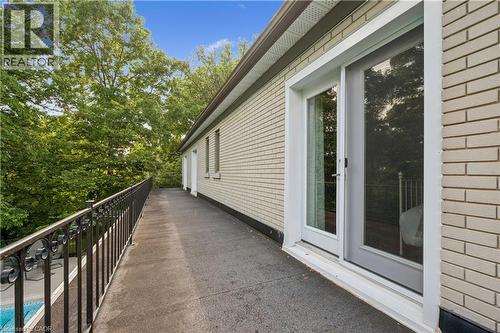 Expansive elevated patio featuring a black wrought-iron railing, brick exterior, and a glass-paneled sliding door - 267 Abraham Street, Cambridge, ON - Outdoor With Exterior