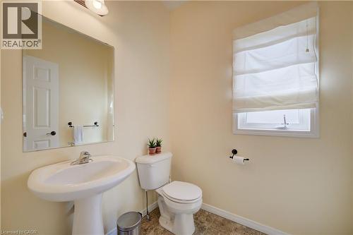 Pedestal sink with chrome faucet, wall-mounted mirror, toilet, window with roman shade, and Linoleum flooring - 64 Kropf Drive, Baden, ON - Indoor Photo Showing Bathroom