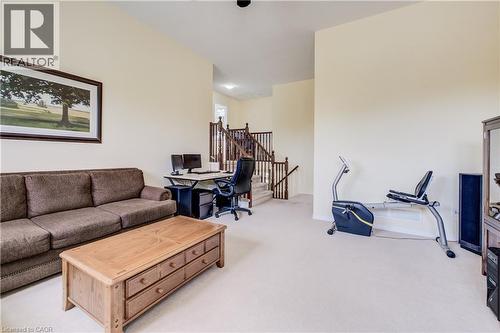 Carpeted flooring, light neutral wall paint, and a wood-finish staircase with white risers and dark wood handrails - 64 Kropf Drive, Baden, ON - Indoor Photo Showing Other Room