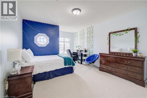 ceiling light, octagon window, large window with multi-pane design, light blue wall color, and carpeted flooring - 64 Kropf Drive, Baden, ON - Indoor Photo Showing Bedroom