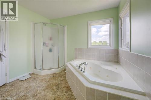 Built-in corner soaking tub with tile surround, separate glass-enclosed shower, and lineoleum flooring - 64 Kropf Drive, Baden, ON - Indoor Photo Showing Bathroom