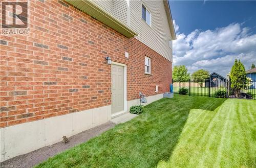 Brick exterior with a side entry door, vinyl siding, a fenced yard, and established landscaping - 64 Kropf Drive, Baden, ON - Outdoor