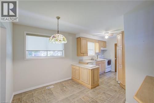 Kitchen area featuring light wood-finish cabinetry, tile flooring, and a built-in kitchen island - 52 Queenston Crescent, Kitchener, ON - Indoor Photo Showing Dining Room