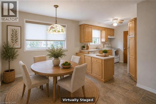 Eat-in kitchen featuring light wood cabinetry, white countertops, tile flooring, and a kitchen island - 52 Queenston Crescent, Kitchener, ON - Indoor Photo Showing Kitchen