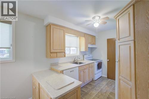 Kitchen featuring light wood cabinetry, light-toned countertops, white appliances, and tiled flooring - 52 Queenston Crescent, Kitchener, ON - Indoor Photo Showing Kitchen