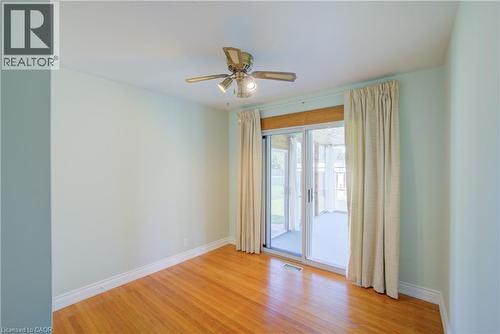 Wood-finish flooring, ceiling fan with integrated lighting, sliding glass door, and pale wall finish - 52 Queenston Crescent, Kitchener, ON - Indoor Photo Showing Bedroom