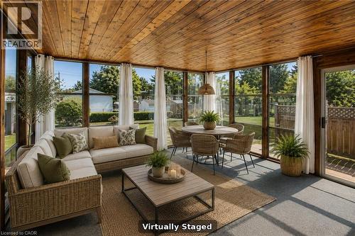 Sunroom featuring a wood-paneled ceiling, expansive window panels, and a sliding glass door - 52 Queenston Crescent, Kitchener, ON -  With Exterior