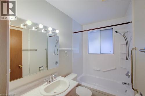 Bathroom featuring a single vanity, integrated sink, mirrored medicine cabinet, and a shower/tub combination with an overhead window - 52 Queenston Crescent, Kitchener, ON - Indoor Photo Showing Bathroom